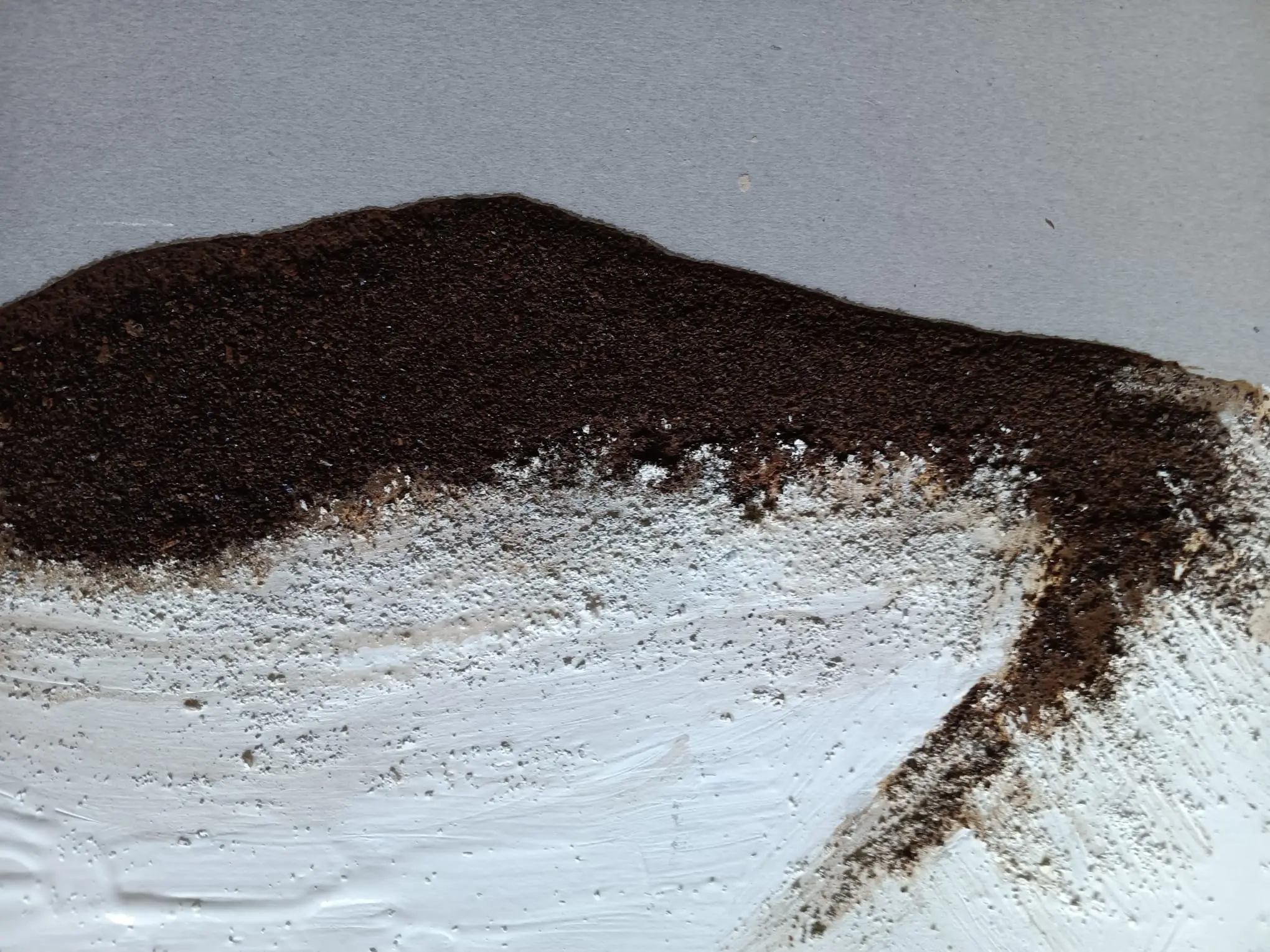 TITLE: ERDENSILHOUETTE  BESCHREIBUNG: Sanfte Hügel aus Kaffeesatz treffen auf rauen, weißen Gips. Ein stilles Zusammenspiel aus Textur, Vergänglichkeit und natürlicher Asymmetrie.